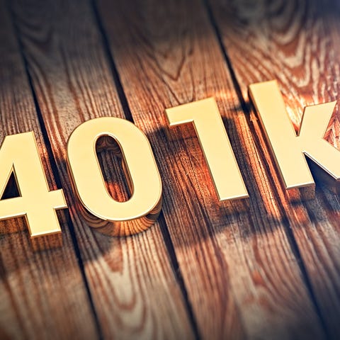 Gold letters reading 401k on wooden planks.