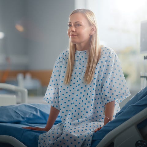 Patient sitting on hospital bed.