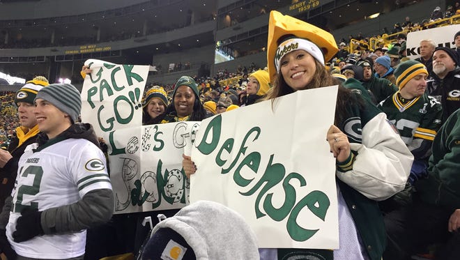 Karen Freeto holds up a homemade sign during a Green Bay Packers game at Lambeau Field. She is one of three wives of slain Texas police officers who were guests of Robinson Metal Inc. and Ashwaubenon Public Safety at the Dec. 8 game between the Green Bay Packers and Atlanta Falcons at Lambeau Field.