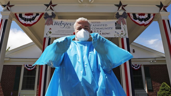 Brendan Williams, president of the New Hampshire Health Care Association, wears an isolation gown with no sleeve openings for hands, which was received in a shipment from the federal government, outside Webster at Rye senior care center on Wednesday, July 1, 2020, in Rye. The problematic gowns, child-sized examination gloves and surgical masks with ear loops that break when stretched make up the bulk of the personal protective equipment recently sent by the Federal Emergency Management Agency to New Hampshire nursing homes, according to Williams. The facility is not using the items they received from FEMA.