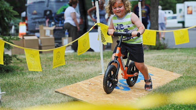 Andrew Barlo, 3, of Sioux Falls, rides a strider through the strider course during Tour Sioux Falls Saturday, June 25, 2016, at Cherry Rock Park in Sioux Falls. 
