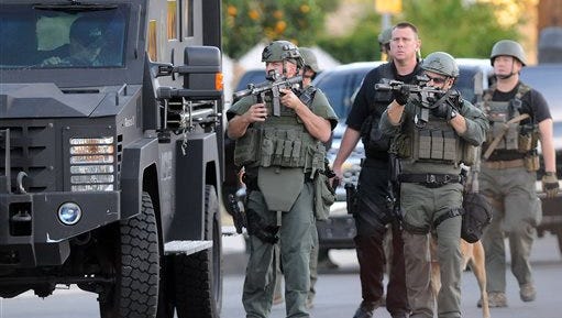 Authorities search an area Wednesday, Dec. 2, 2015, following a shooting that killed multiple people at a social services center for the disabled in San Bernardino, Calif. (James Quigg/The Victor Valley Daily Press via AP) MANDATORY CREDIT
