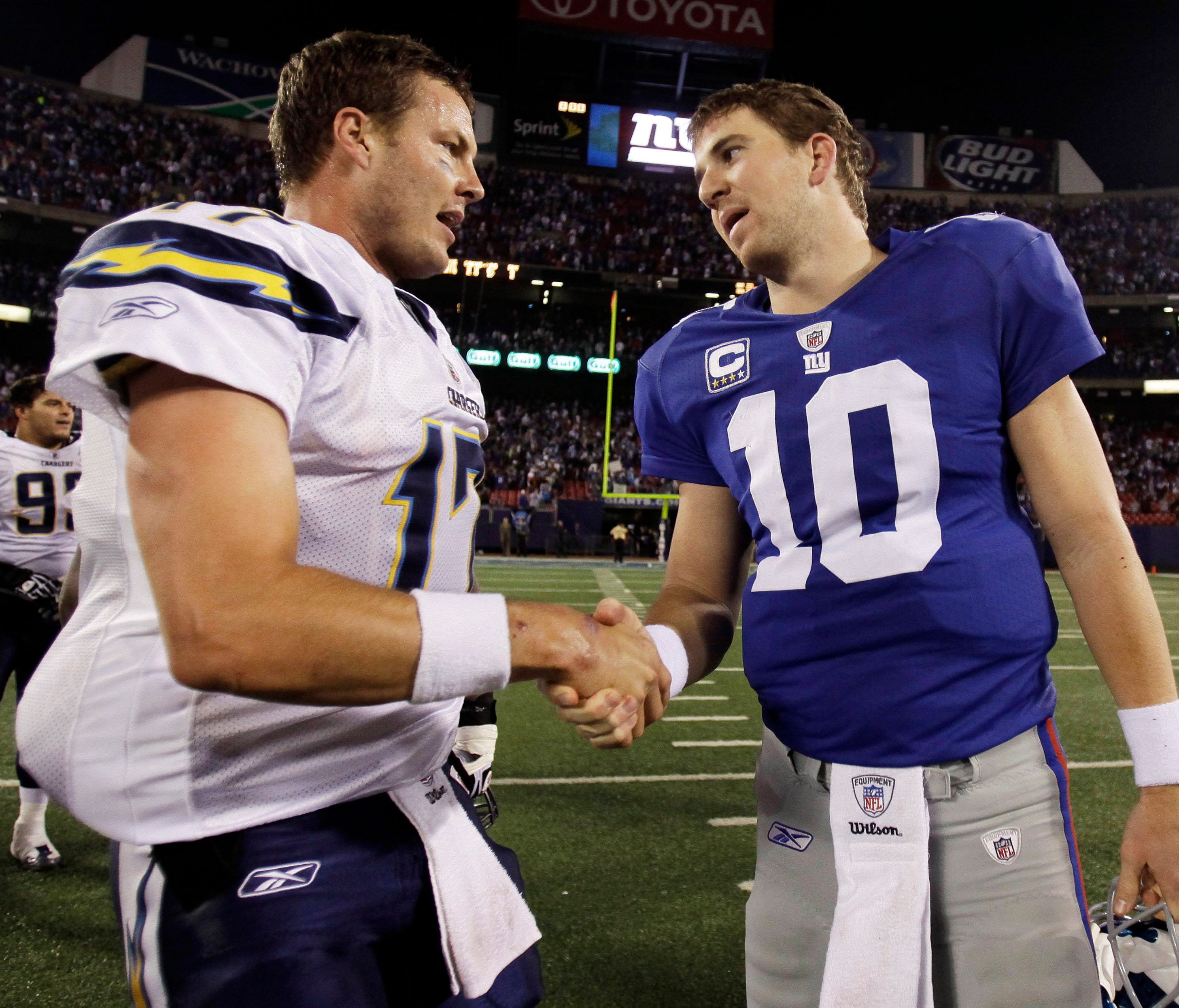 San Diego Chargers quarterback Philip Rivers, left, shakes hands with New York Giants quarterback Eli Manning after an NFL football game. Rivers takes over the quarterback consecutive starts streak now what Manning is being benched.