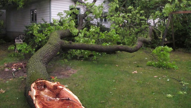 Debris rests on the ground after a garage was damaged by fallen tree during a severe thunderstorm in Traverse City, Mich., Sunday, Aug. 2, 2015. Authorities said gusts as high as 65 mph left thousands without power, damaged houses and left some roads impassable.