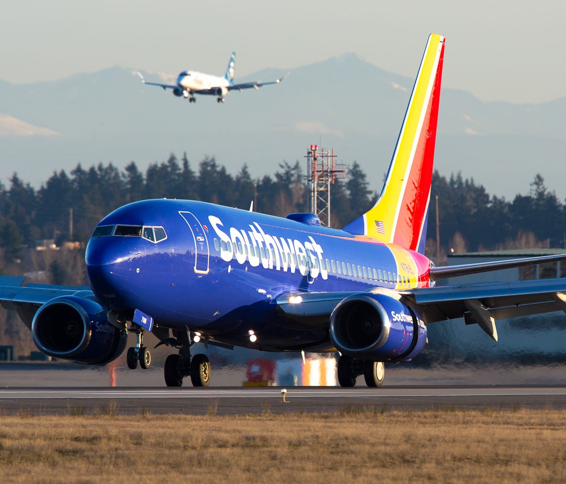 A Southwest Airlines Boeing 737 lands at Seattle-Tacoma International Airport in February 2017 while an Alaska Airlines Embraer E170 shadows it on a nearby runway.