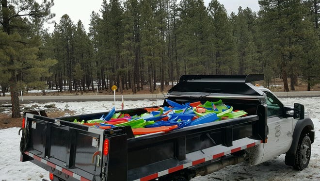 Coconino Sheriff’s Inmate Work Crew pick up sleds left behind from winter recreational activities.