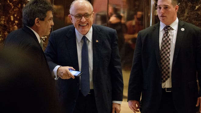 Former New York Mayor Rudy Giuliani, center, smiles as he leaves Trump Tower, Friday, Nov. 11, 2016, in New York.
