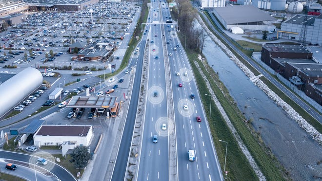 Autonomous vehicles driving down a highway.