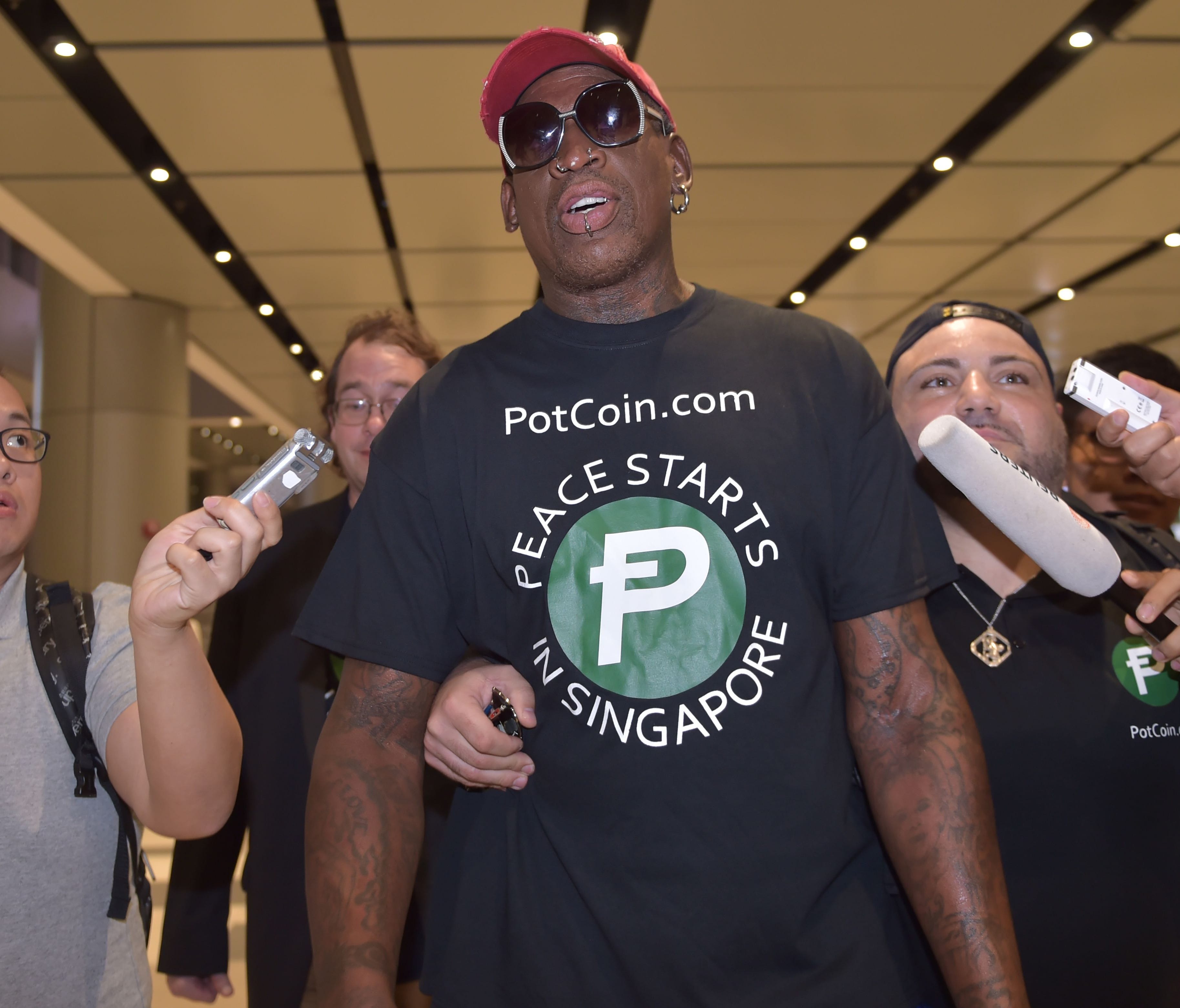 Retired American professional basketball player Dennis Rodman speaks to the press as he arrives at Changi International airport ahead of U.S.-North Korea summit in Singapore on June 11, 2018.