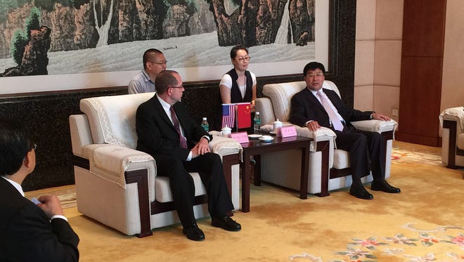 Battle Creek Mayor Dave Walters, left, sits with the secretary of Shandong Province in China and two interpreters during a formal ceremony and news conference.