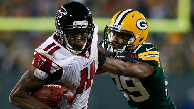 Falcons receiver Julio Jones looks to run after catching a pass against Packers cornerback Casey Hayward.