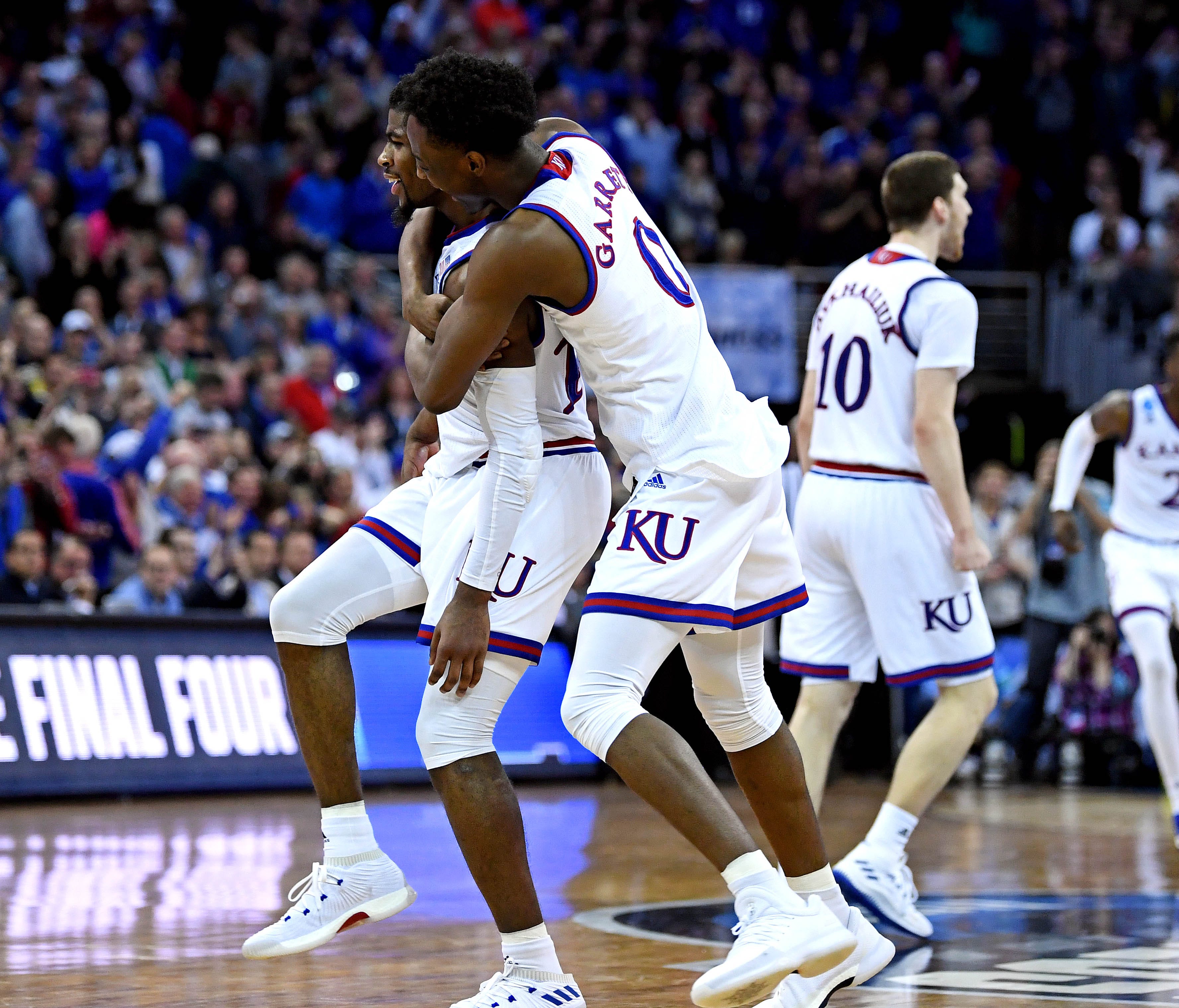 Kansas teammates Marcus Garrett (0) and Malik Newman celebrate after beating Duke in the championship game of the Midwest regional of the 2018 NCAA tournament.