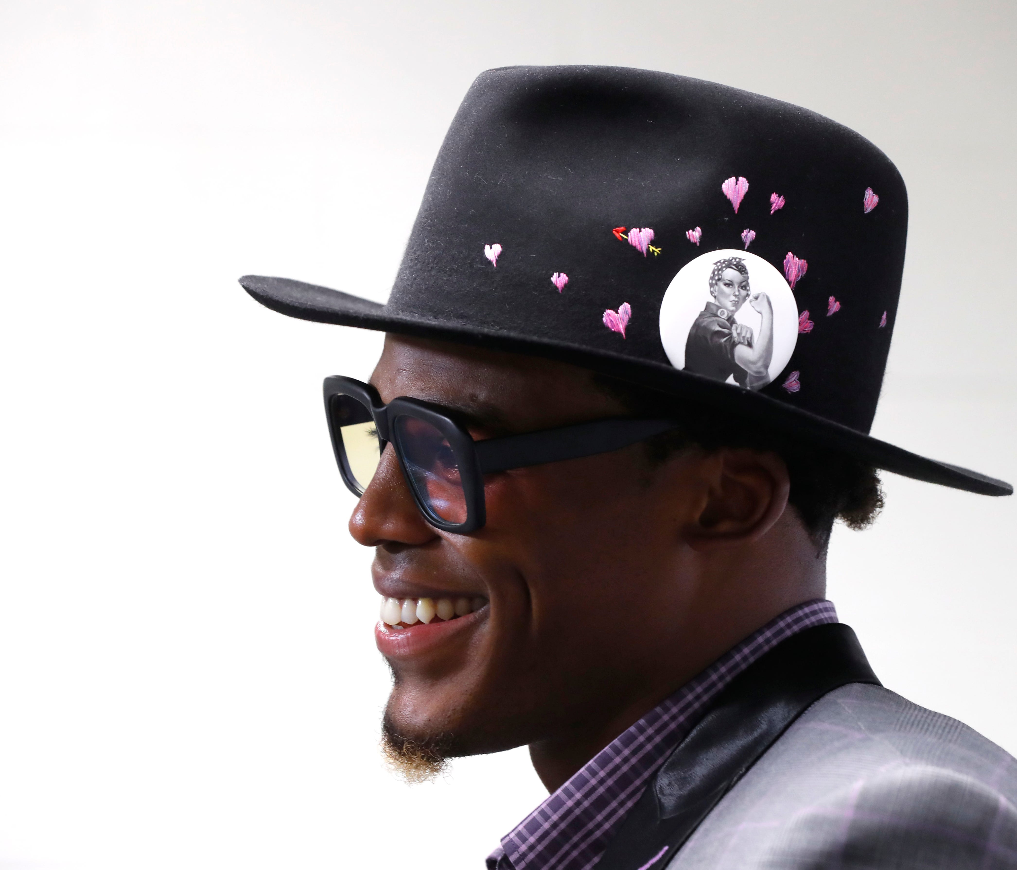 Carolina Panthers quarterback Cam Newton smiles as he speaks after NFL football game against the Detroit Lions in Detroit, Sunday, Oct. 8, 2017. Newton wore a wore a Rosie the Riveter pin on his hat. (AP Photo/Paul Sancya) ORG XMIT: MIPS10