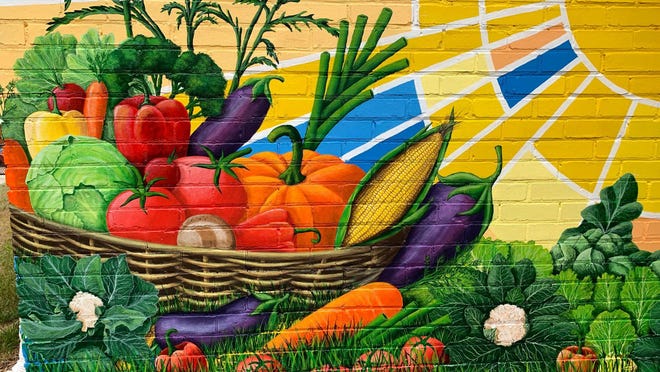 A new mural, painted by Boyce McKinney and designed by Terry Rhyne, is visible at the Mount Holly community garden.