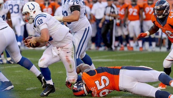Indianapolis Colts quarterback Andrew Luck (12) is tripped up by Denver Broncos defensive end Derek Wolfe (95) late in the fourth quarter at Sports Authority Field at Mile High in Denver on Sunday, September 18, 2016.