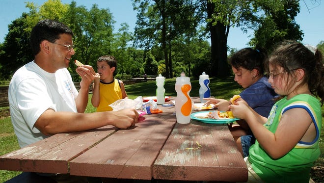 Jonathan Groves, left, has a picnic lunch with children, Nathan, 6, Samantha, 10 and Jenna, 8, at Sequiota Park in 2005.
