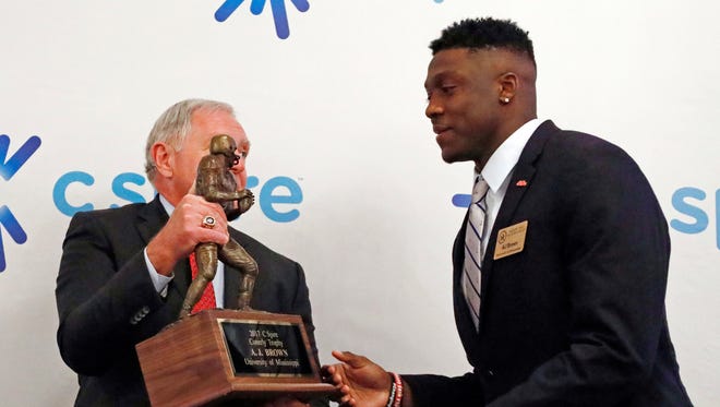 Ole Miss wide receiver A.J. Brown, right, is handed the Conerly Trophy that he was awarded for Mississippi's top college football player, by Bill Blackwell, executive director of the Mississippi Sports Hall of Fame and Museum, during a ceremony in Jackson, Miss., Tuesday, Nov. 28, 2017. (AP Photo/Rogelio V. Solis)