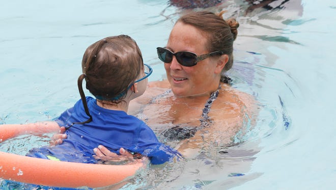 Laurie Tunis, the aquatics director at the Jewish Community Center in West Nyack, teaches a child how to swim on July 14.