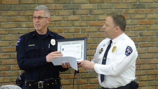 Officer Sam Caldwell receives recognition Tuesday from Bucyrus Police Chief David Koepke. Caldwell was one of 15 officers the chief honored for their exemplary service to the city.
