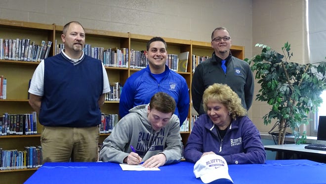 Jack Reed signs his letter of intent to play basketball at Bluffton University. With him are athletic director Tim Ehresman, basketball coach Jason Engel, principal Jeff Holbrook and his mother Melodie Reed.