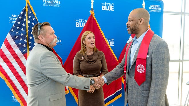 MTSU graduating student veteran Darrell Wright, right, receives a congratulatory handshake from David Corlew as Hilary Miller introduces the pair.