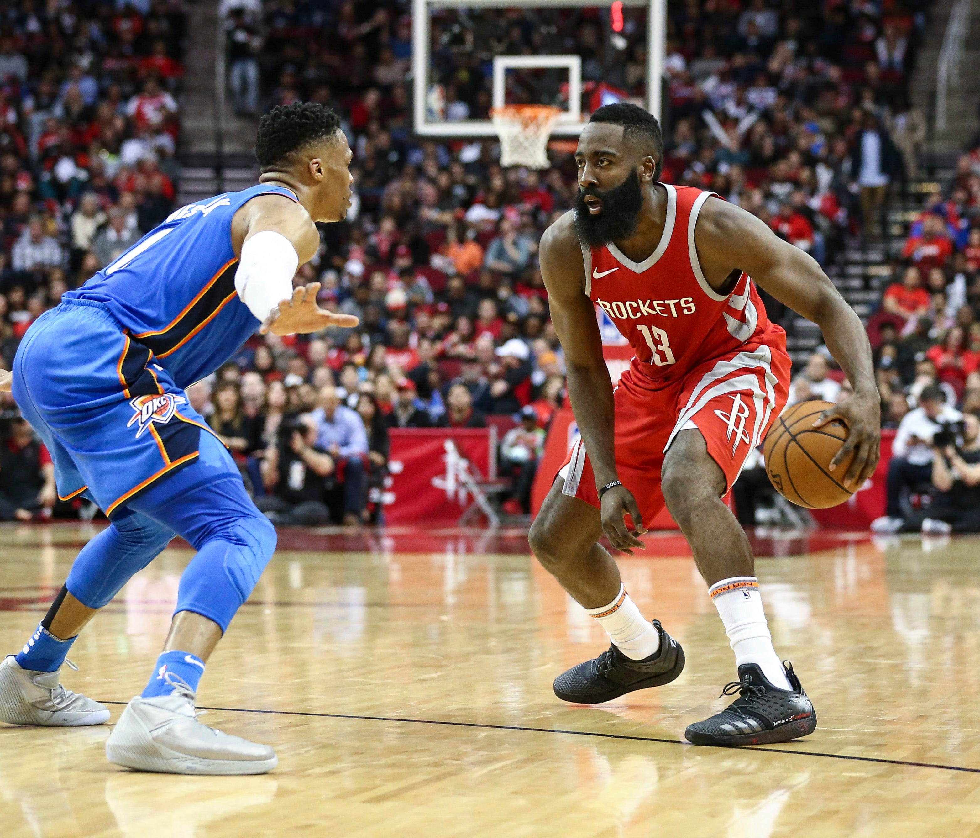Houston Rockets guard James Harden (13) dribbles the ball as Oklahoma City Thunder guard Russell Westbrook (0) defends during the second quarter at Toyota Center.