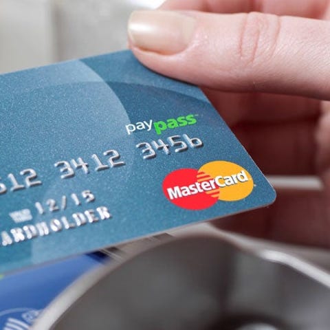 A hand using a payment card with a reader.