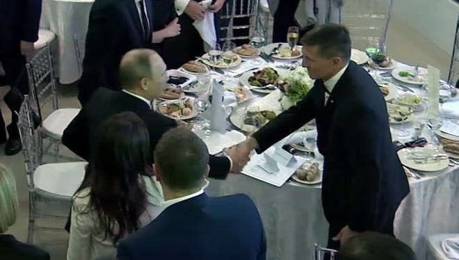 In this image made from a video taken on Dec. 10, 2015 and made available on Tuesday, Feb. 14, 2017, US President Donald Trump's former National Security Advisor Michael Flynn, right, shakes hands with Russian President Vladimir Putin, in Moscow.