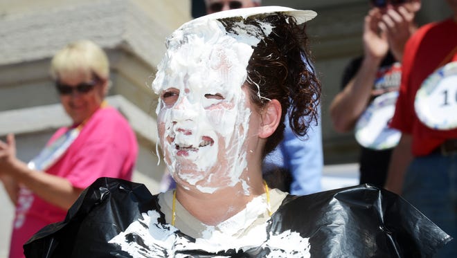 Tiffany McFee of the Zanesville-Muskingum County Health Department wears a plate after getting a face full of whipped cream during the finale of Operation Feed outside the Muskingum County Courthouse on Tuesday. To view more photos, visit www.zanesvilletimesrecorder.come