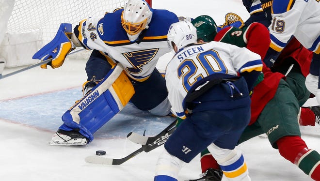 St. Louis Blues goalie Jake Allen, left, stops a shot as Blues' Alexander Steen tries to keep Minnesota Wild's Charlie Coyle, right, away during the first period of an NHL hockey game Tuesday, March 7, 2017, in St. Paul, Minn. (AP Photo/Jim Mone)
