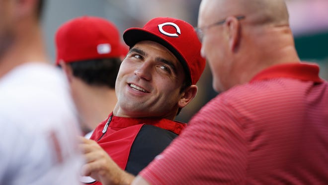 Injured Reds first baseman Joey Votto talks with head athletic trainer Paul Lessard on Aug. 27.