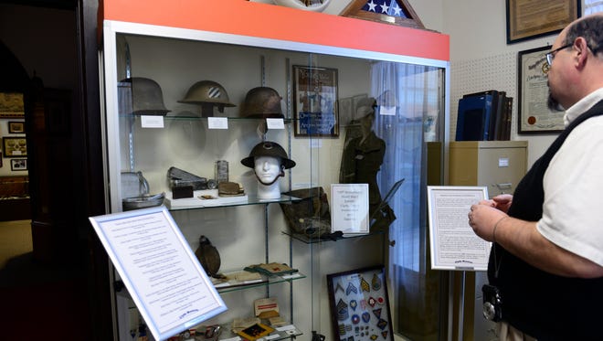 Gene Smith, curator of the Clyde Museum and McPherson House, shows an exhibit of World War I artifacts.
