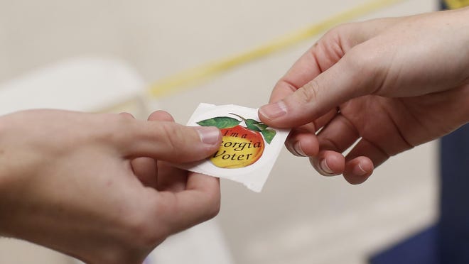 A voter receives a "I'm a Georgia voter" sticker after casting her ballot at the Lay Park Community Center in Athens on Nov. 5, 2019.