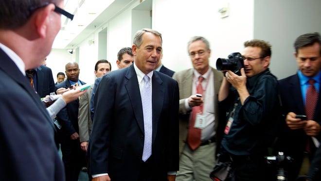 House Speaker John Boehner walks out of a Republican caucus at the U.S. Capitol on Saturday night before the House vote.