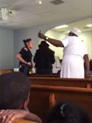 In this screengrab from a cellphone video taken Sunday, Pensacola Police officer Meghan Darling, left, attempts to persuade parties involved in a child custody dispute to exit a local church.