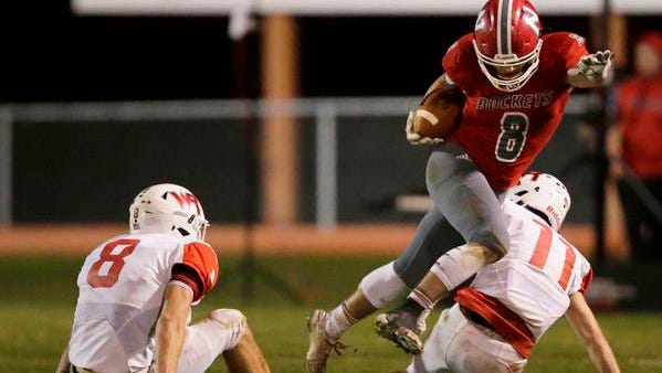 Rayce Prosser of Neenah jumps between Wisconsin Rapids defenders in a Level 1 Division 1 playoff game Friday, October 20, 2017 at Neenah High School in Neenah, Wis.