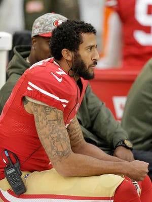 San Francisco 49ers quarterback Colin Kaepernick sits on the sideline during a 2015 game. Now he's getting attention by sitting out the national anthem to protest police brutality.