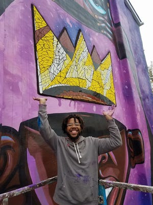 Wilmington’s Terrance Vann taking a break from painting his mural at W. Seventh and N. Jefferson streets last year. He has a new art show, “Inner Visions,” at the baby grand in downtown Wilmington Friday night as part of the city’s monthly Art Loop.