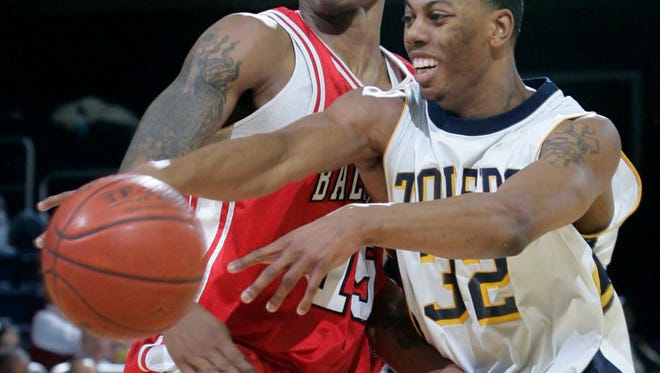 In this Feb. 26, 2006 photo, Toledo's Anton Currie, right, passes during an NCAA college basketball game against Ball State in Toledo, Ohio. Currie pleaded guilty to conspiracy in a decade-old points shaving scandal and admitted accepting cash and other incentives to alter his performance at the University of Toledo. Three other former players are now scheduled for sentencing. (AP Photo/The Blade, Dave Zapotosky)