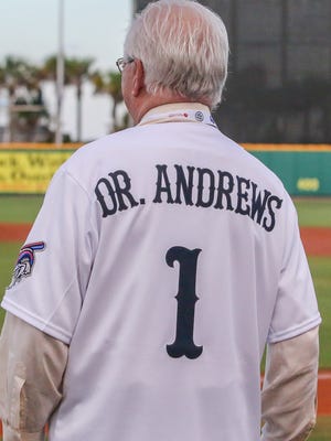 Dr. James Andrews, founding partner and medical director for the Andrews Institute, dones a personalized Blue Wahoos jersey during Dr. James Andrews Appreciation Night at Blue Wahoos Stadium on Friday.