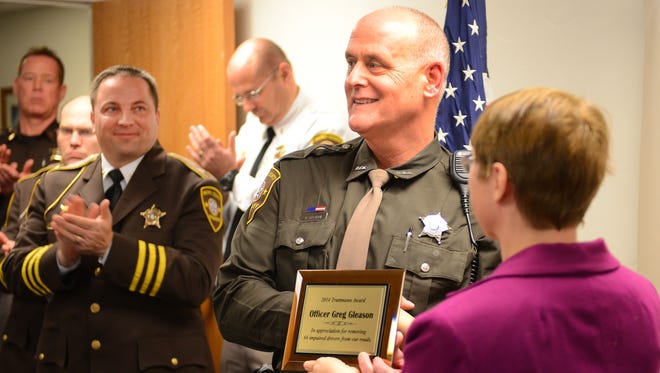Brown County Sheriff's Department Deputy Greg Gleason, center, is awarded the Truttmann Award on Dec. 2, 2014, for making the most drunken driving arrests. Presenting the award is Wanda Truttmann Sieber, daughter of the Brown County sergeant, Jim Truttman, for whom the award is named.