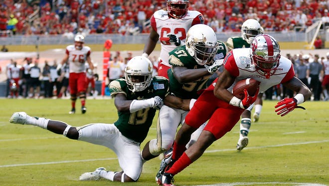 Western Kentucky's Nacarius Fant scores a touchdown as South Florida's Nigel Harris and Ronnie Hoggins tackle hime in the 2015 Miami Beach Bowl at Marlins Park. The Miami Beach Bowl has not had a title sponsor since debuting in 2014.