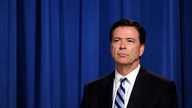 FBI Director James Comey listens during a news conference at the Justice Department in Washington, Monday, June 30, 2014.