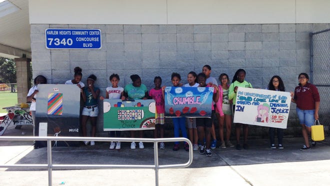 Youth with the Harlem Heights summer program show off the artwork they created for the Human Trafficking Awareness Partnerships’ ARTREACH program.