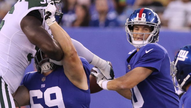 New York Jets defensive end Muhammad Wilkerson gets his hand on the ball but can't knock it away after New York Giants quarterback Eli Manning.