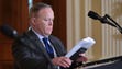 Spicer adjusts papers on the president's lectern before