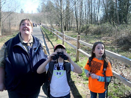 Pack 5239 Den leader Traci Siasat, left, looks at a hawk flying on the Clear Creek Trail with Tiger Scouts Trygger Carter, 6, and Annabeth Taylor, 7.