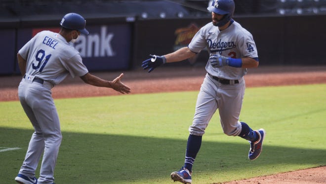 Los Angeles Dodgers' Chris Taylor celebrates with third base coach Dino Ebel, a Barstow native, after hitting a solo home run off San Diego Padres relief pitcher Garrett Richards during the sixth inning Wednesday, Sept. 16, 2020, in San Diego.
