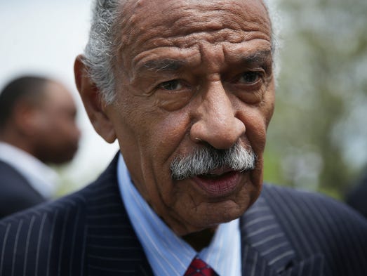 Rep. John Conyers speaks to a reporter at the end of