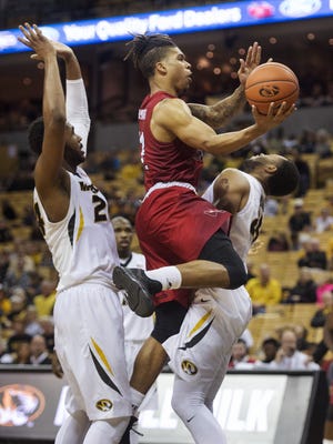 Western Kentucky's Pancake Thomas, center, shoots between Missouri's Kevin Puryear, left, and Russell Woods, right, during the second half of an NCAA college basketball game Saturday, Dec. 3, 2016, in Columbia, Mo. Missouri won the game 59-56. (AP Photo/L.G. Patterson)